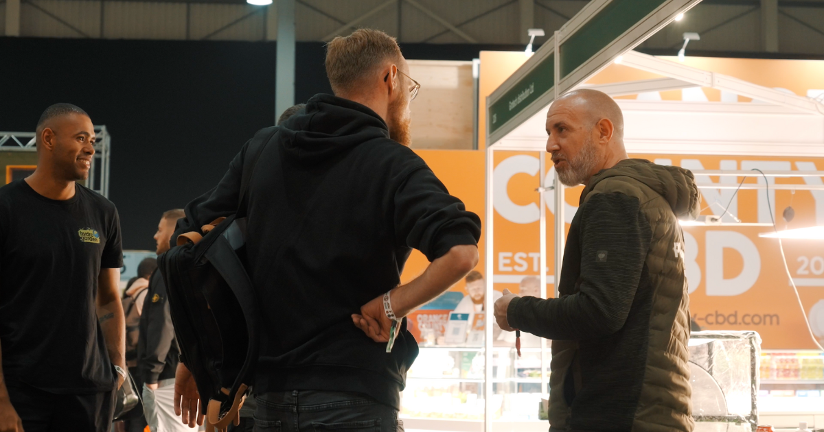 Two men talking at a CBD stand at an expo