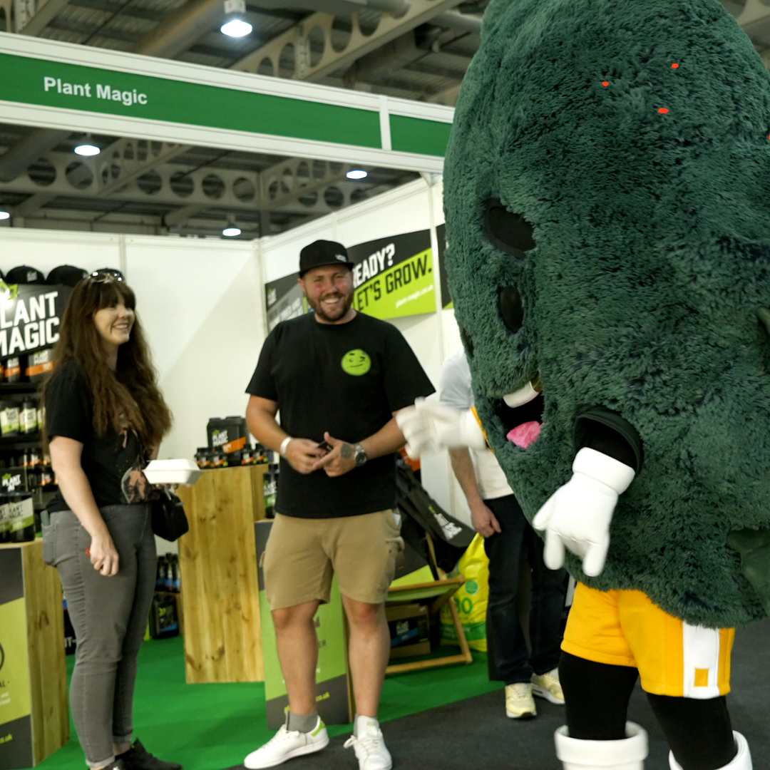 a mascot in front of an expo stand